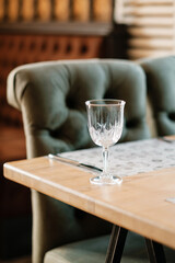 Green armchair in an empty cafe during pandemic. No guests. Served table.