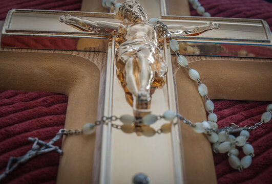 Crucifix and rosary beads of Catholic religion closeup in selective focus.