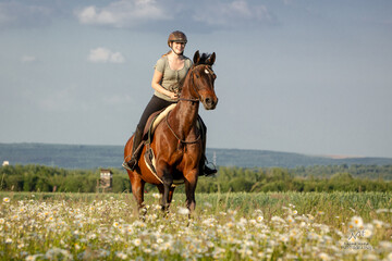 Mädchen galoppiert mit Pferd durch Blumen