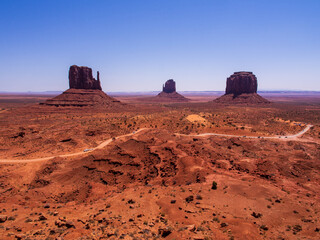 Road across Monument Valley with famous stone formations.
