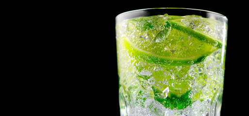 Mojito cocktail in a glass on a table in summer bar, Alcohol cocktails with Rum, lime, mint, ice cubes and brown sugar closeup, Party drink. Isolated on black background, selective focus