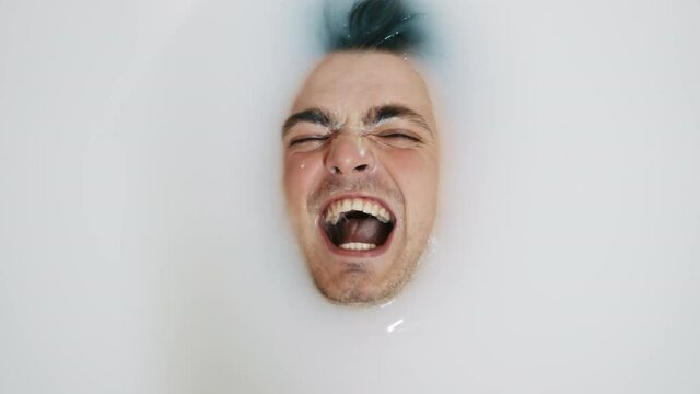 Portrait of funny man do crazy laughing in milk bath, evil laughter.