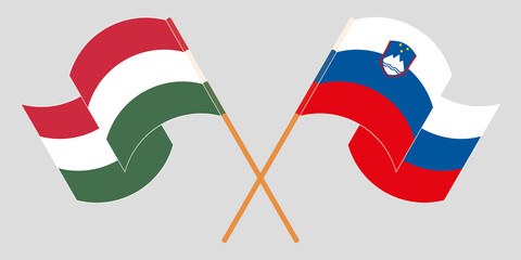 Crossed and waving flags of Slovenia and Hungary