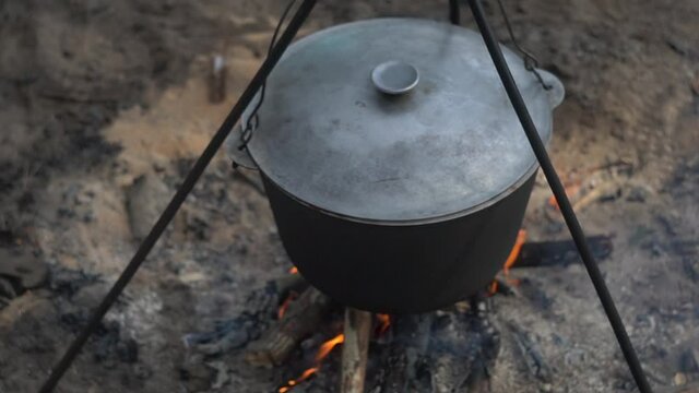 cauldron at the stake. camping in the wood. cooking on the fire. field kitchen. in a pot coming to a boil. a fire built up under a wash pot for scalding water. soup in his bowl.