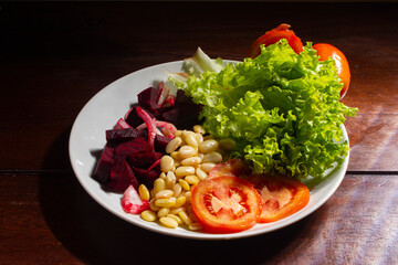 Vegan food. Plate of lettuce, beet, fava and tomato