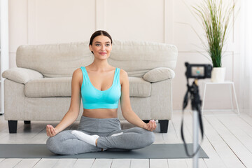 Fototapeta na wymiar Yoga Blogger Making Video Sitting In Lotus Position At Home
