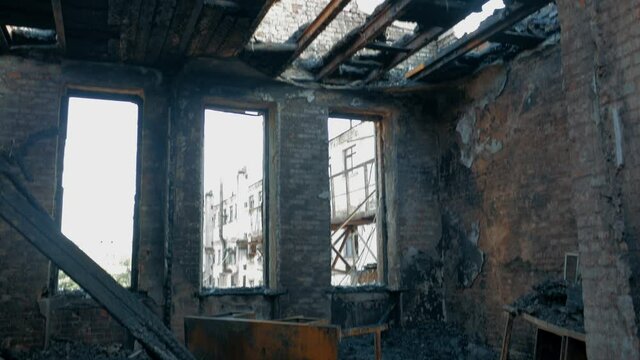 Burned house inside damaged by fire with burnt furniture and roof
