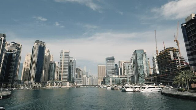 Dubai Marina with skyscrapers and blue sky, view from water boat in water chanel, UAE