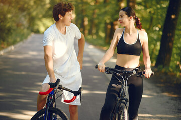 Obraz premium People with a bikes. Couple in a forest. Morning bike ride.