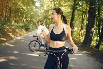 Obraz premium People with a bikes. Couple in a forest. Morning bike ride.