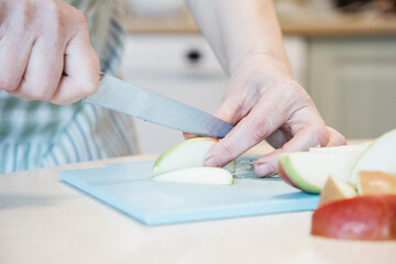 A person cutting a piece of apple on a table