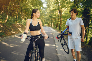 Obraz premium People with a bikes. Couple in a forest. Morning bike ride.
