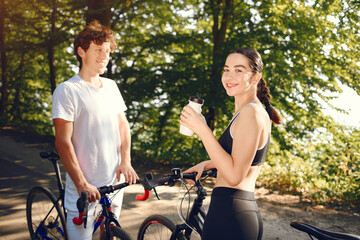 Obraz premium People with a bikes. Couple in a forest. Morning bike ride.
