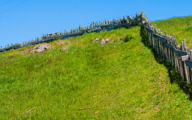 Fototapeta na wymiar Old Wooden Fence Reaching Across Green Pasture on Marshall-Petaluma Road Near Marshall,California, USA