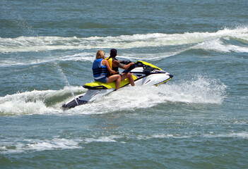 Two men riding tandem on a speeding jet ski.

