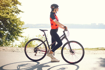 Fototapeta premium Woman with a bike. Sportswoman in a forest. Morning bike ride.