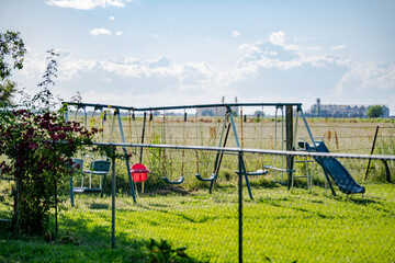 Fototapeta na wymiar Swing set next to a pasture