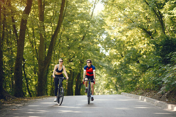 Fototapeta premium People with a bikes. Couple in a forest. Morning bike ride.