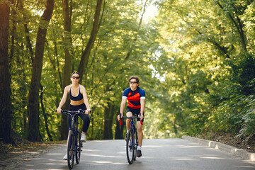 People with a bikes. Couple in a forest. Morning bike ride.