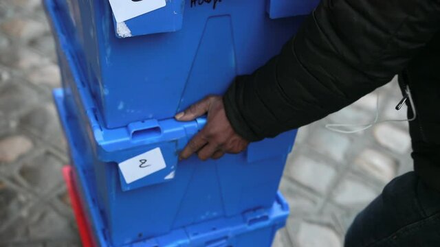 Close Up. The Hands Of An African-American Male Push Blue Boxes With Goods. Food Delivery, Street Courier