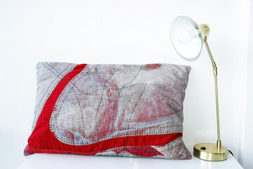 Lamp and pillow
Gold table lamp and grey-red pillow are on the table. 25 May 2020. The fabric ...