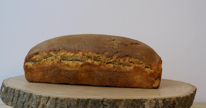A dynamic closeup of real sourdough bread on a local revolver on a wooden board in warm colors with a white background