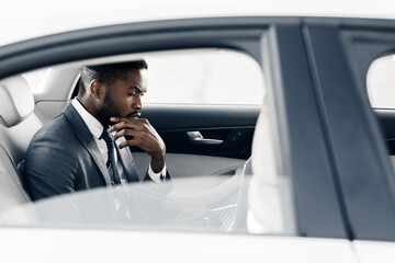 Thoughtful African Businessman Working Sitting On Back Seat In Car