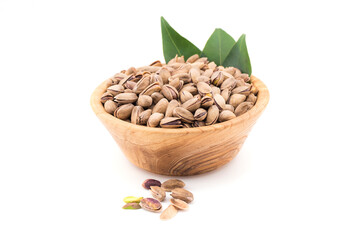Close up of pistachio nut on wooden bowl on white background