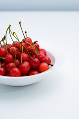 Fresh cherries in a white porcelain dish.