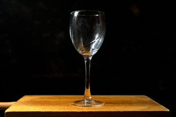 glass goblet on black background on wooden table