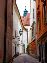 Bright orange and ochre-colored buildings line curving narrow street in Graz, Austria.