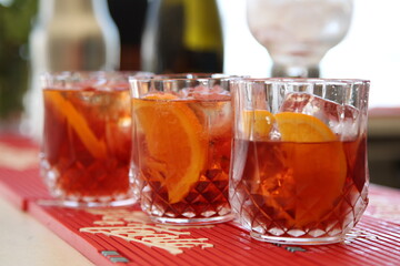 Beautiful bar glasses with alcoholic cocktail and citrus inside