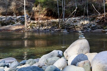 Smooth rounded river rocks and a man made cairn on the shore of Englishman River in Parksville, on...