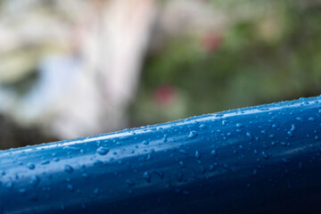 Blue handrail in rain.