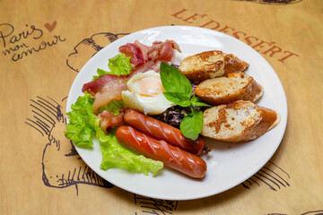 Fried eggs with sausages and bread on a plate, traditional breakfast