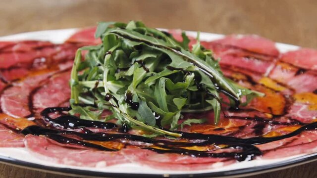 Carpaccio with rucola and balsamic sauce. The beautiful dish in the restaurant. Beautiful serving of carpaccio at the restaurant. Dish of carpaccio.