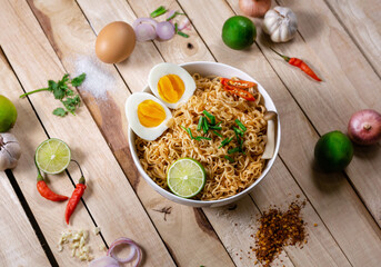 Instant noodles in bowl on wood background top view, Asian meal on a table.