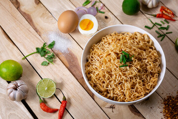 Instant noodles in bowl on wood background top view, Asian meal on a table.