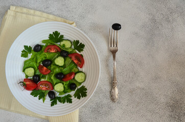 Super food fresh vegetable salad with cherry tomato cucumber black olives with parsley and lettuce top view. The concept of healthy food and dieting. Copy space text. Nutrition for a slim figure