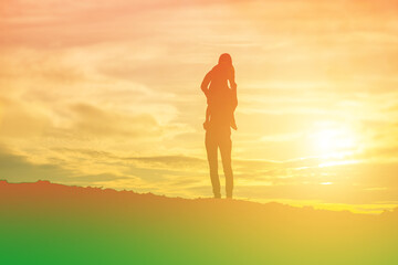 Mother encouraged her daughter out of the shadows at sunset.
