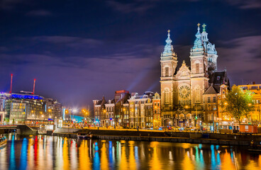Fototapeta na wymiar Night city view of Amsterdam canal and Basilica of Saint Nicholas, Holland, Netherlands.