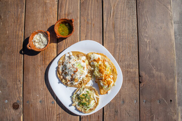 top view variety of mexican food like sope, tacos and quesadilla With sauce