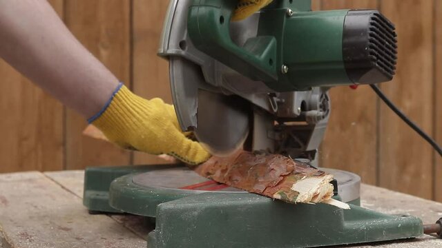 cut a wooden board with an electric saw

