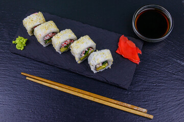 Uramaki sushi rolls with surimi on a black slate