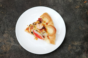 Delicious Italian food Sliced of Pizza on White dish and black concrete floor.