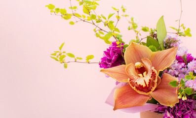 Bunch of beautiful flowers, orchid isolated on light pink background. Close-up. Florist shop or feast concept
