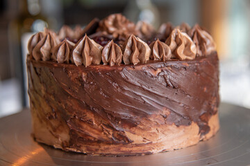 Close up on beautifully decorated and presented chocolate fudge cake with stunning topping. 