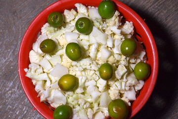 Berry and chopped cauliflower kept in a red colored basket used for vegetable and salad
