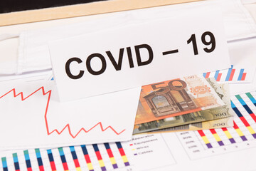 Currencies euro with downward graphs representing financial crisis caused by coronavirus. Covid-19