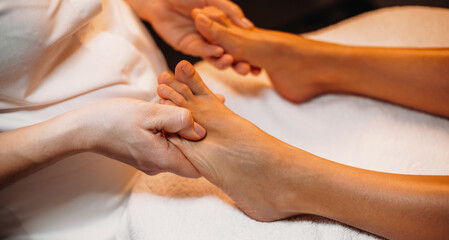Fototapeta na wymiar Professional masseur having a foot massage treatment in the spa salon